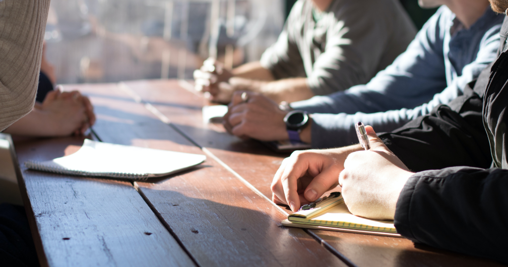 People writing in a meeting