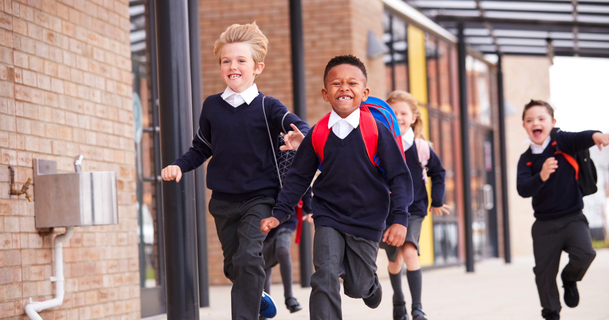 A small group of children running outside school