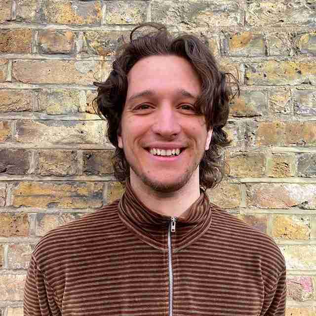 Photo shows Ollie in the MP Smarter Travel team. It is a head shot. He is wearing a brown striped zipped top.