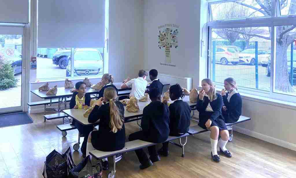 Children at school having breakfast. These are children who have taken part in a Bike or Walking Bus. When they get to school, they have a special breakfast laid for them.