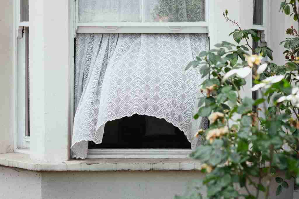 Open sash window. White lace curtain is blowing out of the window towards the camera.
This is to demonstrate a simple way of ventilating the home.