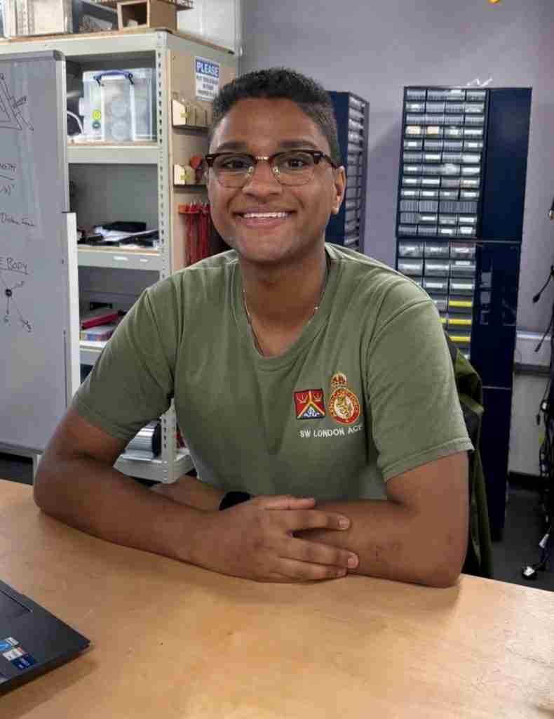 the image shows a portrait shot of Nicholas Solly, the author of this blog.
He is wearing a green t-shirt and is sitting behind a desk in a lab.